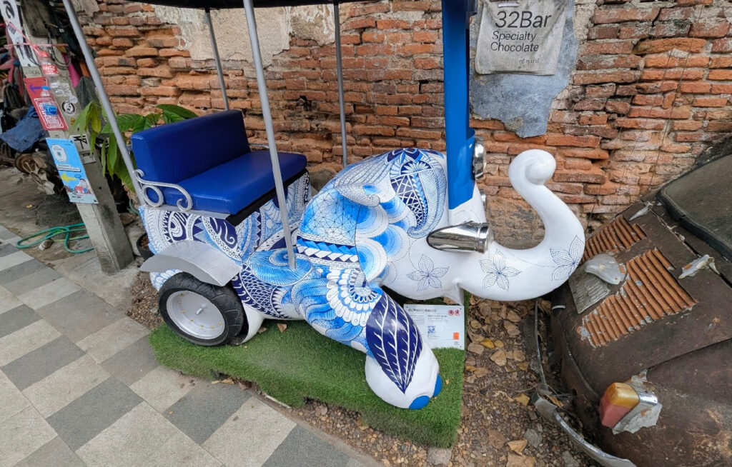 Det du ser her er en skulptur som kombinerer to av Thailands mest ikoniske symboler: elefanten og den trehjulte taxien Tuk-Tuk.