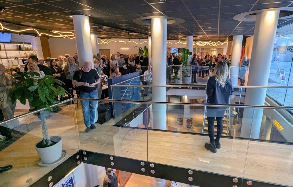 En kvinne holder tale fra mesaninen foran en folkemengde under åpningen av Scandic GO i Grensen, Oslo.