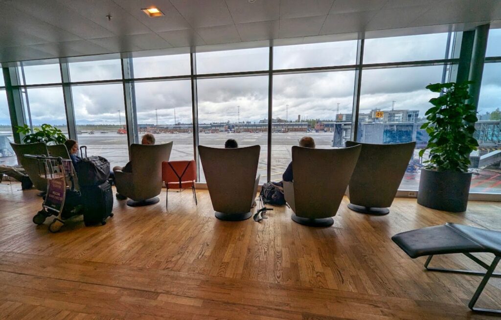 Sitteplasser og hvilesone med store vinduer og utsikt mot rullebanen på Oslo Lufthavn Gardermoen non-Schengen område F.