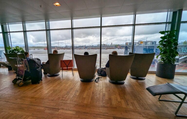 Sitteplasser og hvilesone med store vinduer og utsikt mot rullebanen på Oslo Lufthavn Gardermoen non-Schengen område F.